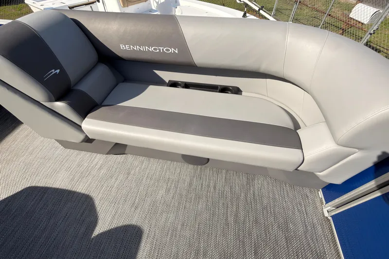 Slide: The Image of 2024 Bennington SVL boat seat with gray upholstery and integrated cup holders. - 14