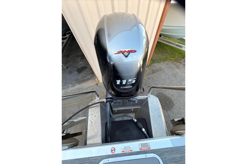 Slide: The Image of 2024 Bennington SVL boat with Yamaha 115 outboard motor in a garage setting. - 23