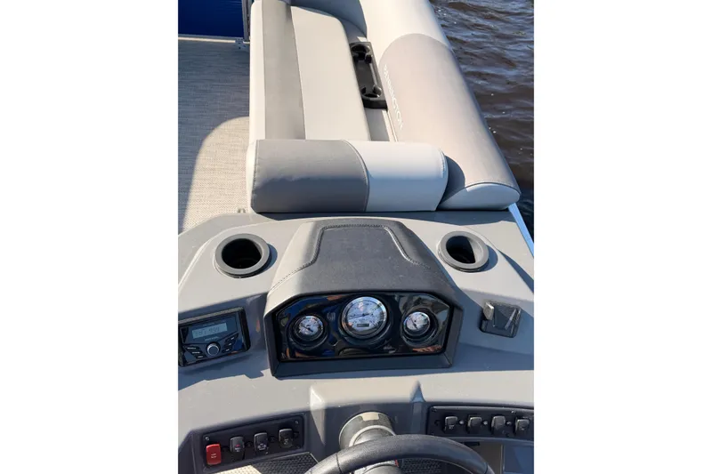 Slide: The Image of 2024 Bennington SVL boat dashboard with gauges and seating, on water. - 24