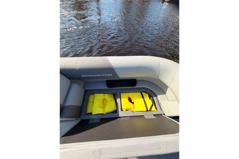 Slide: The Image of 2024 Bennington SVL boat interior with storage compartment and yellow life jackets. - 25