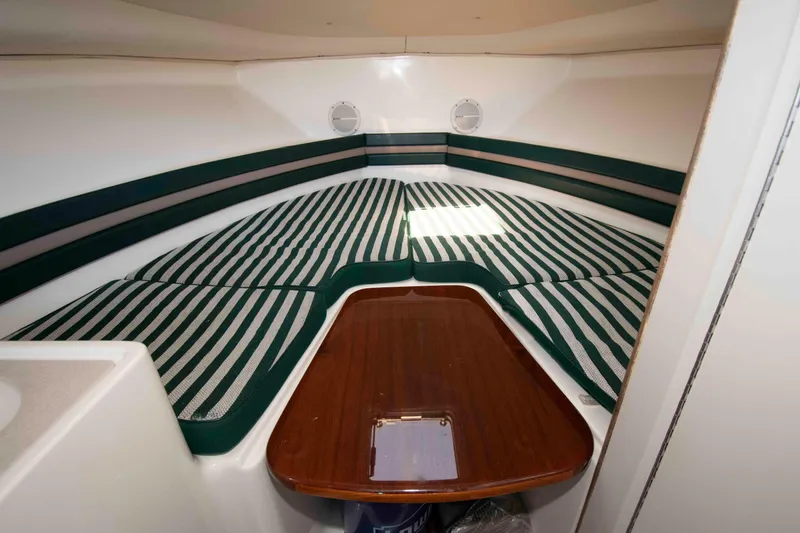 Slide: The Image of Interior cabin of 2000 Pursuit 2860 Denali boat with striped cushions and wooden table. - 13