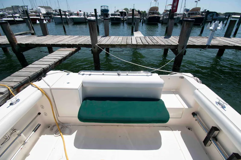 Slide: The Image of 2000 Pursuit 2860 Denali boat interior with green seating at a marina dock. - 8