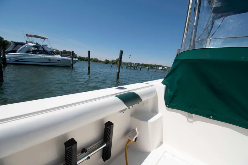Slide: The Image of 2000 Pursuit 2860 Denali boat docked in a serene marina setting. - 9