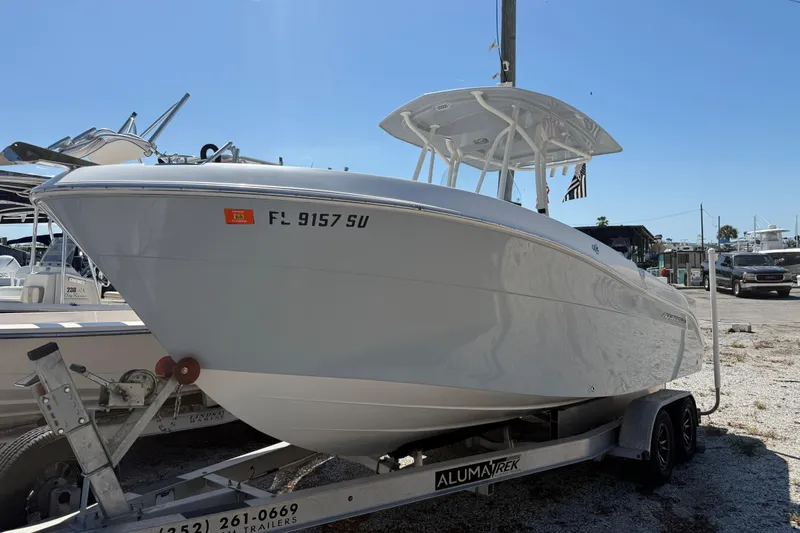 The Image of 2022 Aquasport 2300 Center Console boat on trailer in sunny marina. - 0