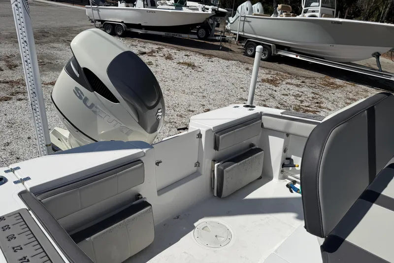 Slide: The Image of 2022 Aquasport 2300 Center Console boat with Suzuki outboard motor, docked on gravel. - 11