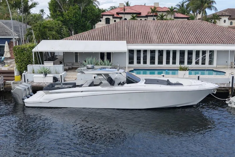 The Image of 2023 Canados 493 Gladiator yacht docked by a luxurious waterfront home. - 0