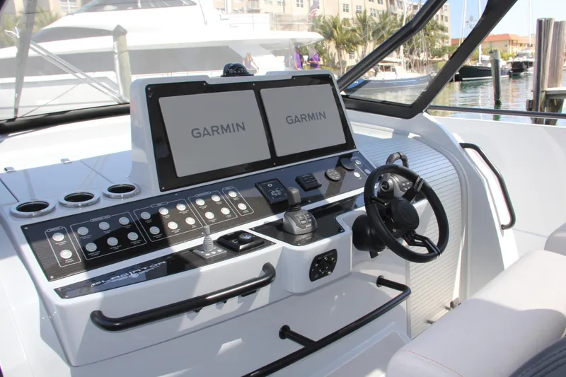 Slide: The Image of 2023 Canados 493 Gladiator yacht cockpit with Garmin navigation displays and control panel. - 2