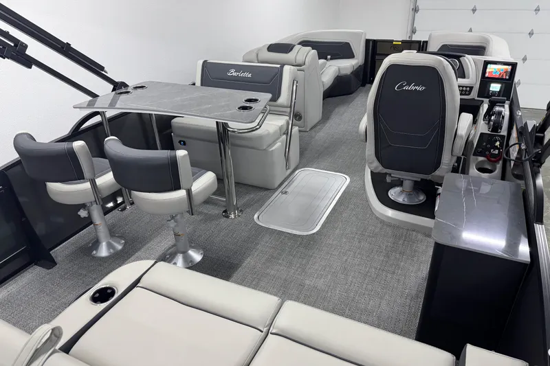 Slide: The Image of 2026 Barletta Cabrio 24UE pontoon boat interior with modern seating and control panel. - 13