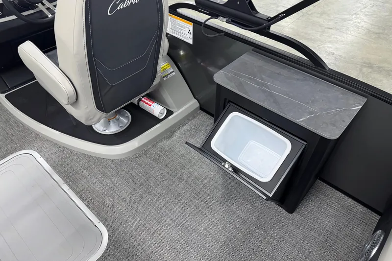 Slide: The Image of 2026 Barletta Cabrio 24UE boat interior with seat and open storage compartment. - 16