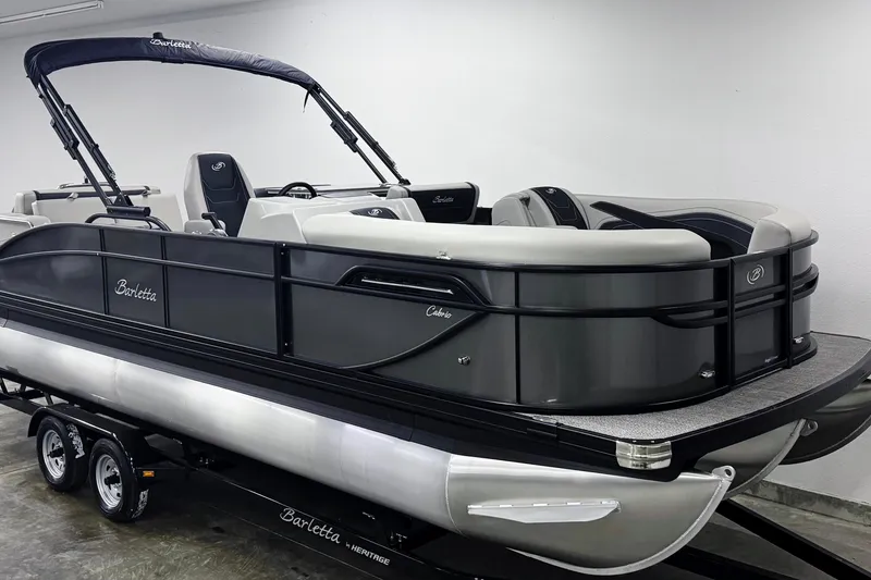 Slide: The Image of 2026 Barletta Cabrio 24UE pontoon boat on trailer in showroom. - 2
