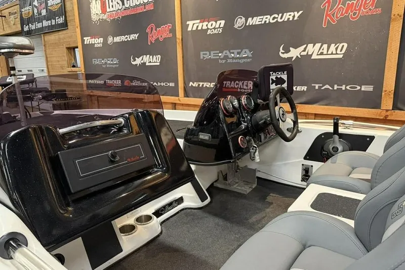 Slide: The Image of 2010 Bass Cat Puma boat interior with steering console and branded backdrop. - 10