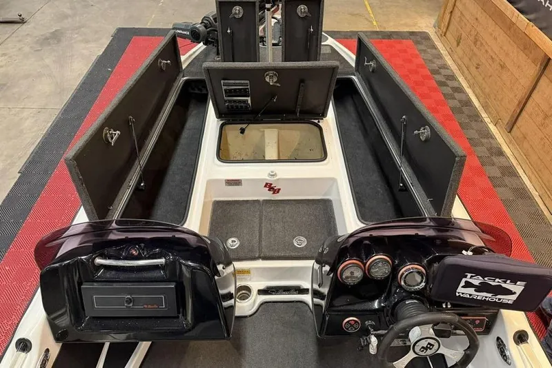Slide: The Image of 2010 Bass Cat Puma boat interior with open storage compartments and steering console. - 12