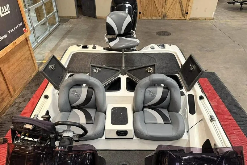 Slide: The Image of 2010 Bass Cat Puma boat interior with gray seats and open storage compartments. - 13