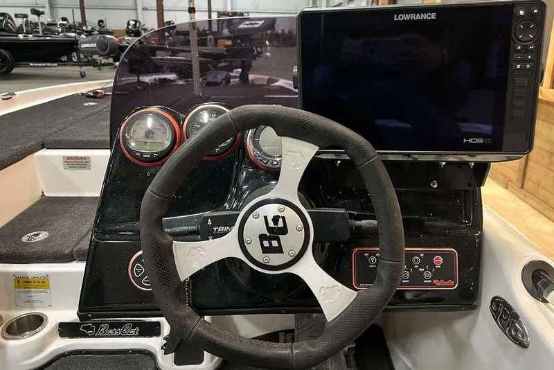 Slide: The Image of 2010 Bass Cat Puma boat dashboard with steering wheel and Lowrance HDS display. - 5