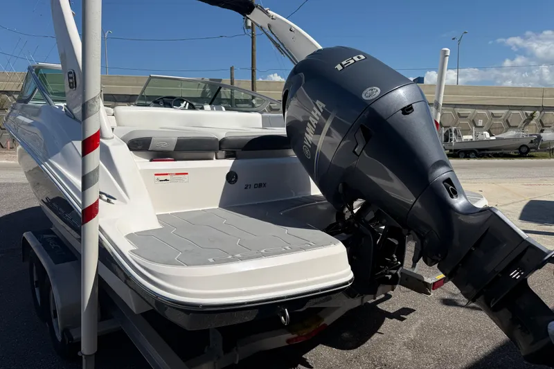 Slide: The Image of 2019 Regal 21 OBX boat with Yamaha 150 outboard motor, parked on a trailer. - 4