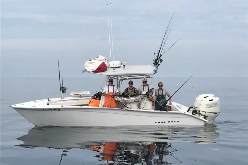 Slide: The Image of 2007 Cape Horn 24 OS boat with fishermen holding a large catch on calm waters. - 13