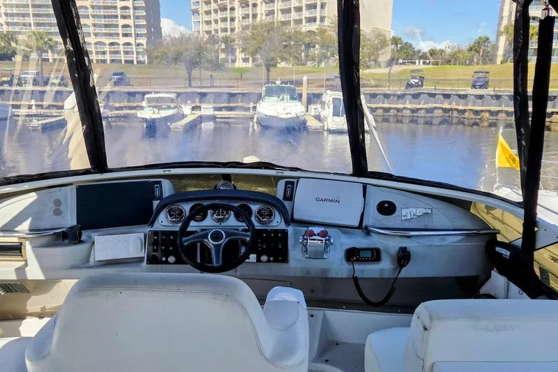 Slide: The Image of Interior view of 2000 Carver 396 Motor Yacht helm with marina backdrop. - 12