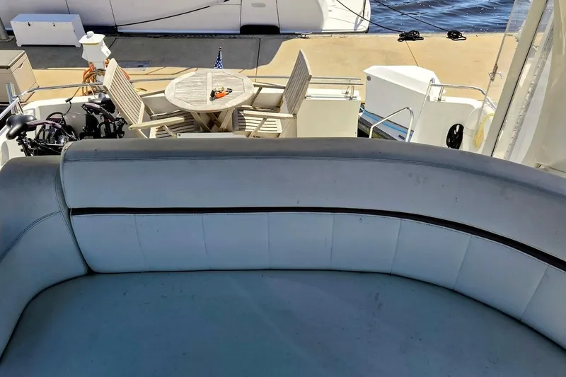 Slide: The Image of 2000 Carver 396 Motor Yacht deck with seating and table, docked by the water. - 15