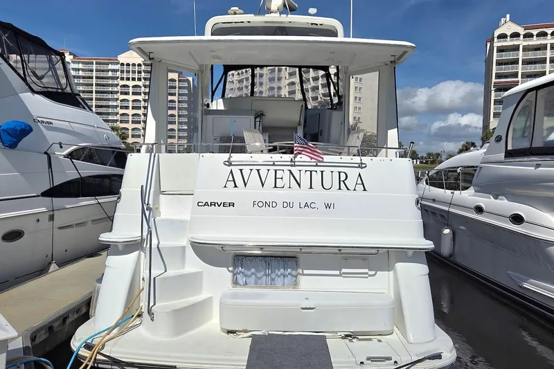 Slide: The Image of Carver 396 Motor Yacht 2000 docked, displaying "AVVENTURA" and American flag. - 19