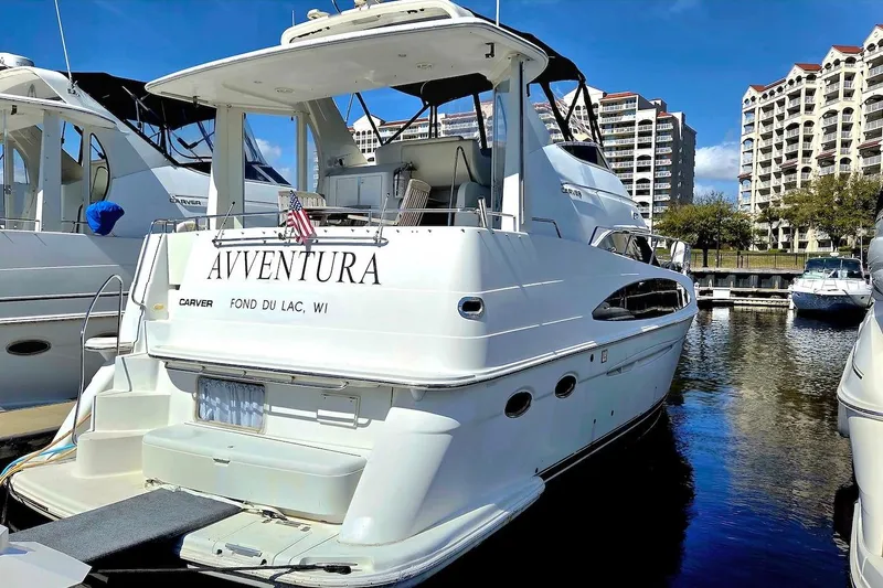 Slide: The Image of 2000 Carver 396 Motor Yacht docked, featuring "AVVENTURA" name, in a marina setting. - 2