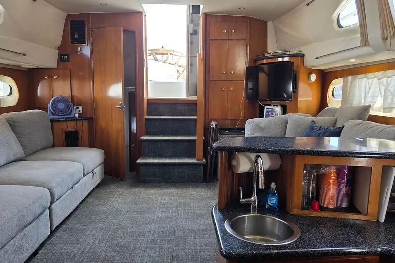 Slide: The Image of Interior of a 2000 Carver 396 Motor Yacht with modern furnishings and kitchenette. - 22