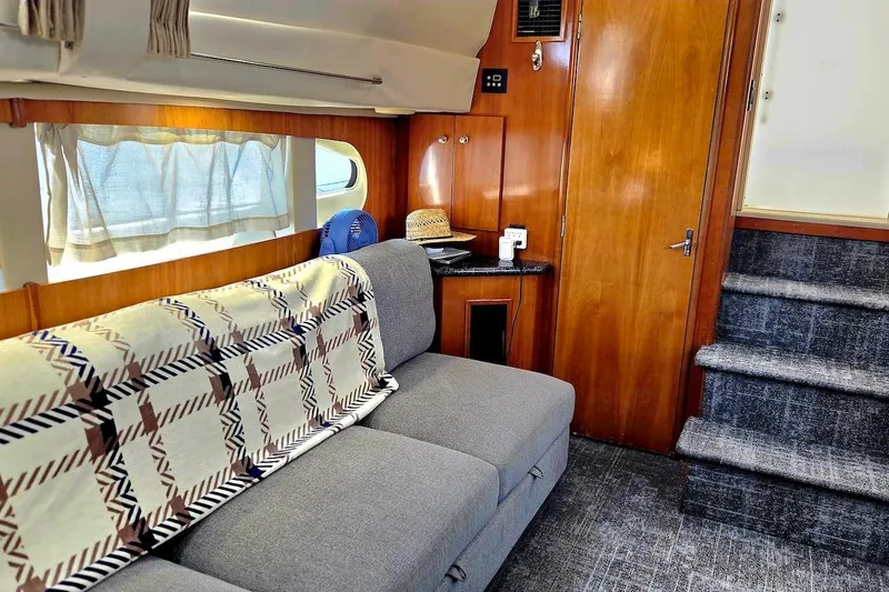 Slide: The Image of Interior of 2000 Carver 396 Motor Yacht with cozy seating and wooden accents. - 27