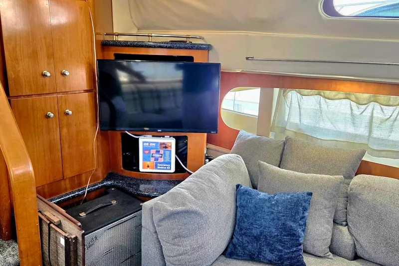 Slide: The Image of Interior of 2000 Carver 396 Motor Yacht with TV, sofa, and wooden cabinetry. - 28