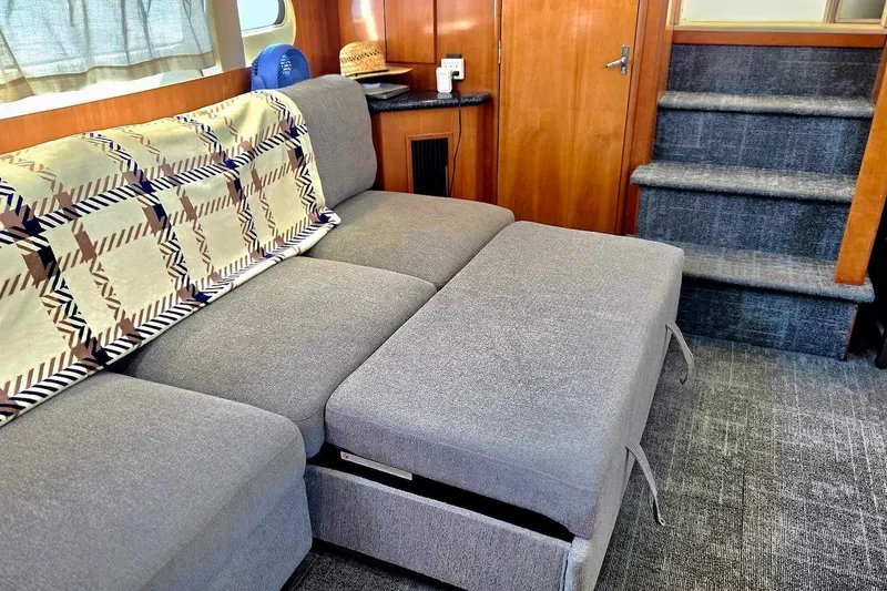 Slide: The Image of Interior of 2000 Carver 396 Motor Yacht with gray sofa and patterned throw blanket. - 32