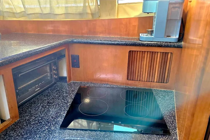 Slide: The Image of 2000 Carver 396 Motor Yacht kitchen with stove, microwave, and coffee maker. - 33