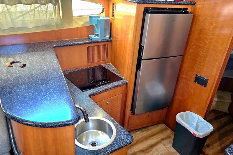 Slide: The Image of Interior of 2000 Carver 396 Motor Yacht kitchen with sink, stove, and refrigerator. - 34