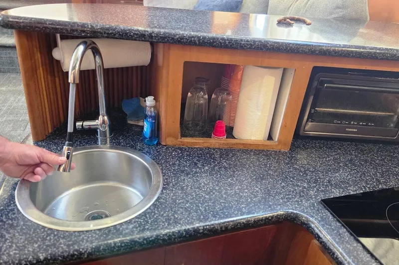 Slide: The Image of 2000 Carver 396 Motor Yacht kitchen with sink, faucet, and countertop essentials. - 37