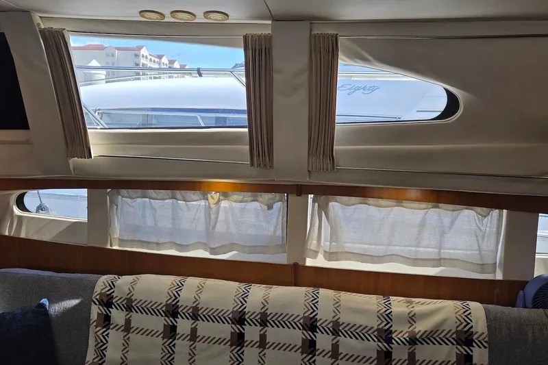 Slide: The Image of Interior view of 2000 Carver 396 Motor Yacht with window curtains and plaid blanket. - 38