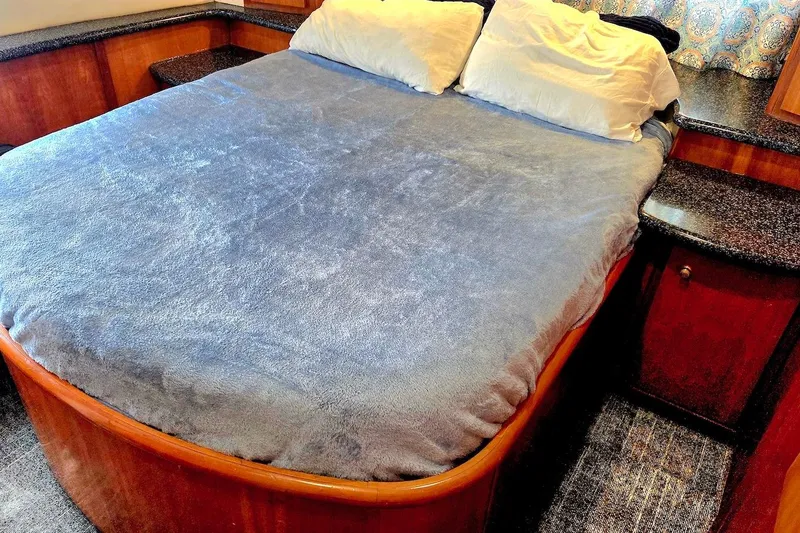 Slide: The Image of Cozy bedroom interior of 2000 Carver 396 Motor Yacht with plush bedding and wooden accents. - 39
