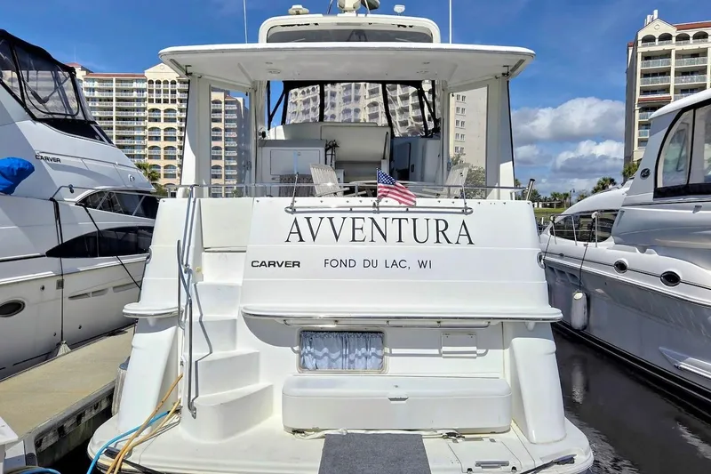 Slide: The Image of Carver 396 Motor Yacht 2000 docked, featuring "AVVENTURA" name and American flag. - 4