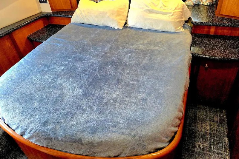 Slide: The Image of Cozy bedroom in 2000 Carver 396 Motor Yacht with plush bedding and wooden accents. - 40