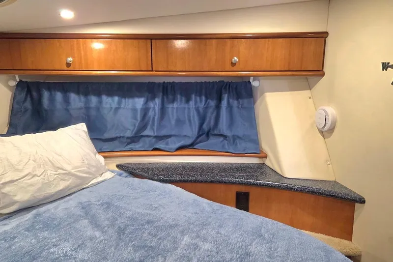 Slide: The Image of Cozy interior cabin of 2000 Carver 396 Motor Yacht with blue bedding and wooden cabinets. - 41