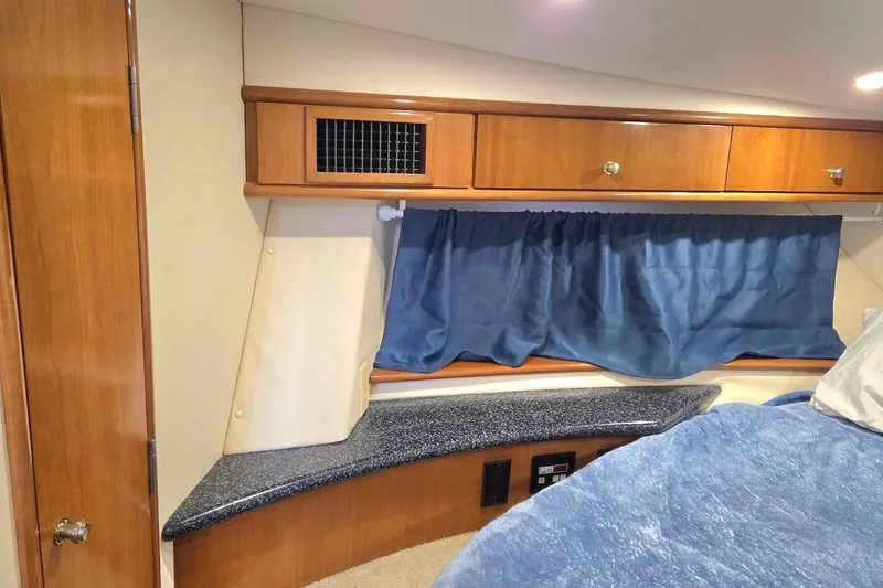 Slide: The Image of Interior cabin of 2000 Carver 396 Motor Yacht with wood cabinets and blue curtains. - 43