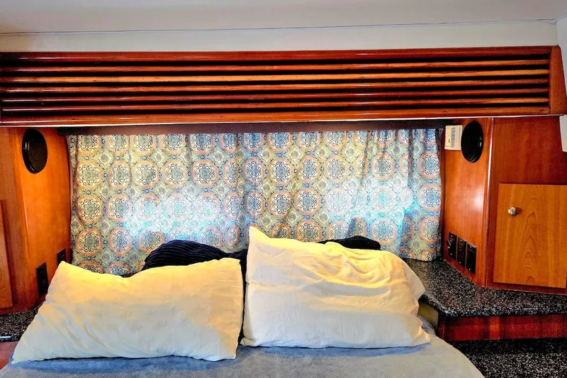 Slide: The Image of Interior of 2000 Carver 396 Motor Yacht with patterned curtains and cozy bedding. - 52
