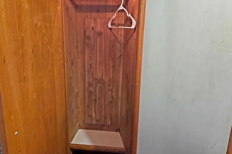 Slide: The Image of Wooden closet interior with a hanger, inside a 2000 Carver 396 Motor Yacht. - 55