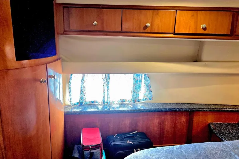 Slide: The Image of Interior of 2000 Carver 396 Motor Yacht with wooden cabinets and luggage. - 56