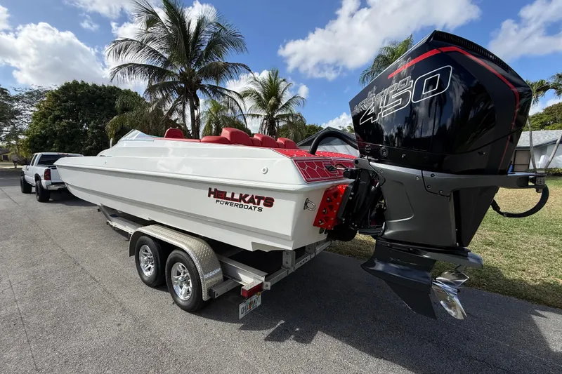 Slide: The Image of 2020 HellKats 30 powerboat on trailer, featuring a powerful 450 engine, parked near palm trees. - 11