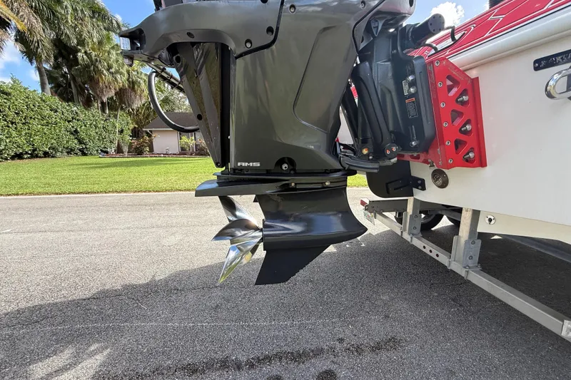 Slide: The Image of Outboard motor of a 2020 HellKats 30 boat on a trailer, parked on a sunny street. - 18