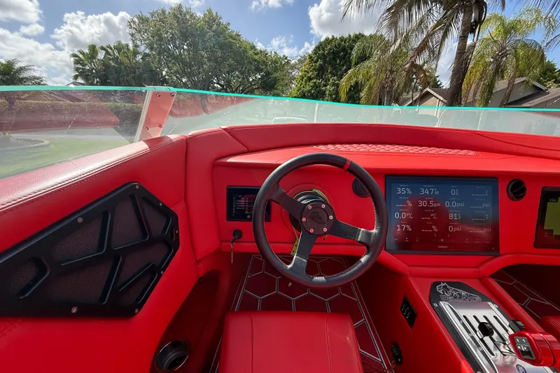 Slide: The Image of Red interior of a 2020 HellKats 30 boat with digital dashboard and steering wheel. - 31