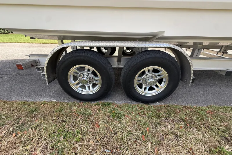 Slide: The Image of Trailer with dual wheels for HellKats 30 boat, 2020 model, parked on grass. - 62