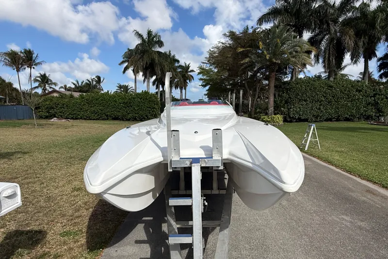 Slide: The Image of 2020 HellKats 30 boat on trailer, surrounded by palm trees and blue sky. - 8
