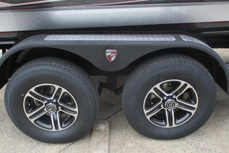 Slide: The Image of 2026 Triton 19 TrX Patriot trailer wheels with stylish alloy rims and branded fender. - 10