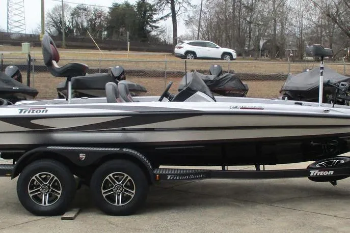 Slide: The Image of 2026 Triton 19 TrX Patriot boat on trailer, parked outdoors. - 8
