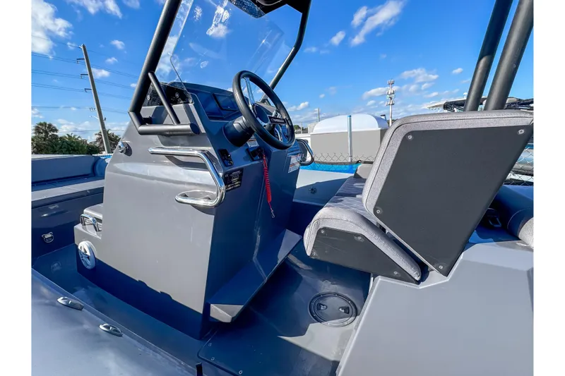 Slide: The Image of 2024 Northstar Orion 8 boat cockpit with steering wheel and seating, under clear blue sky. - 6