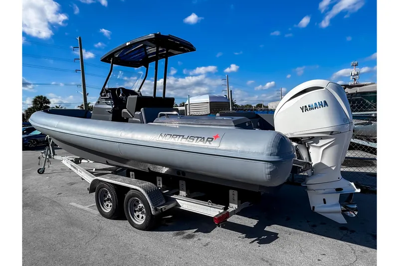 Slide: The Image of 2024 Northstar Orion 8 boat on trailer with Yamaha engine, under clear blue sky. - 2