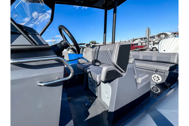 Slide: The Image of 2024 Northstar Orion 8 boat interior with steering wheel and seating, under clear blue sky. - 7